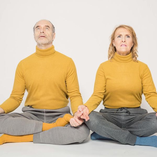 Smiling woman sitting peacefully after a yoga session.